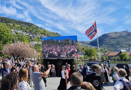Mange folk samlet på Festplassen i Bergen på 17. mai, med Ulriken i bakgrunnen.
