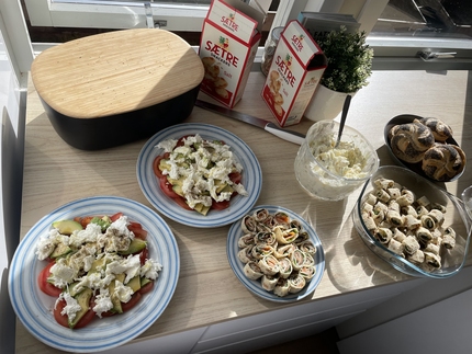 Bord dekket til 17. mai-frokost. Ulike retter som lefserull og salat. 