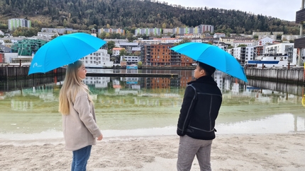 To studenter ved Marineholmen, med hver sin lyseblå paraply