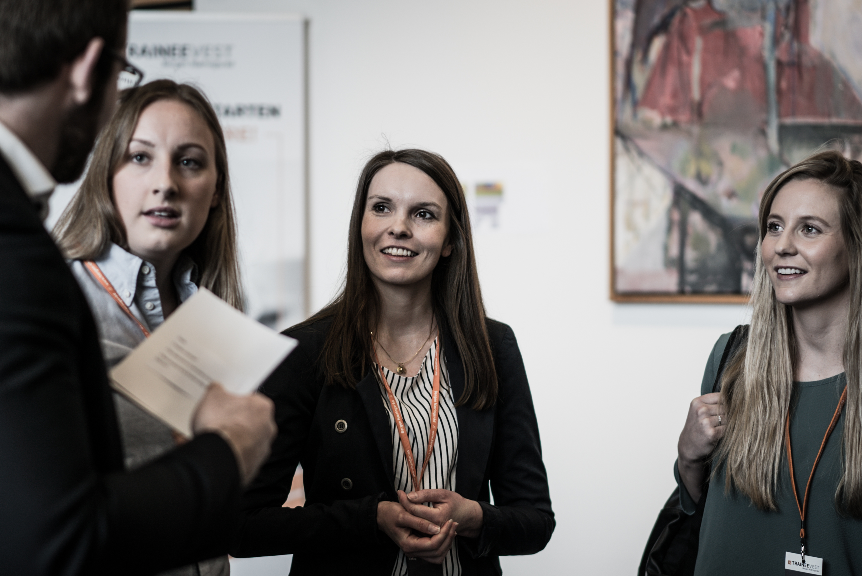 Fire personer i samtale i et kontorlandskap.