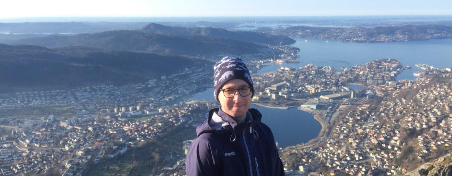 Tonny Wullf Tommy på toppen av et byfjell med Bergen i bakgrunnen.