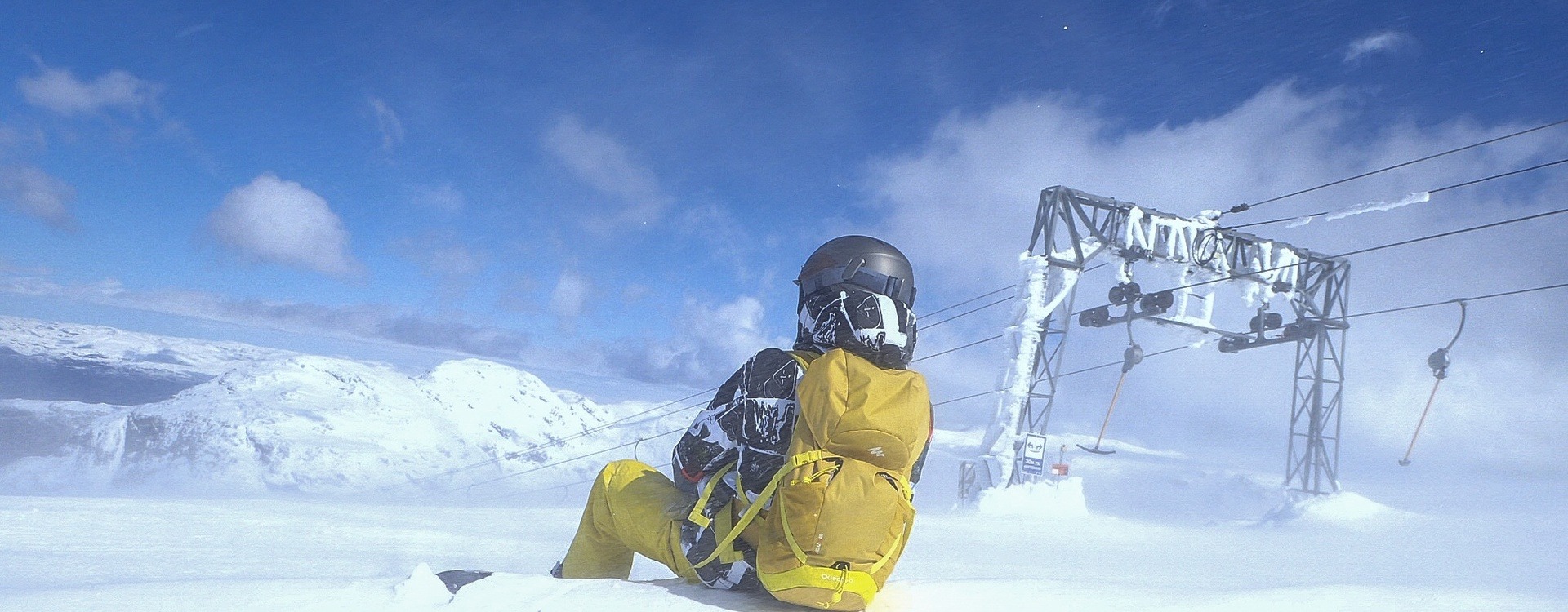 Snowboarder sitter på toppen av Fonna skisenter