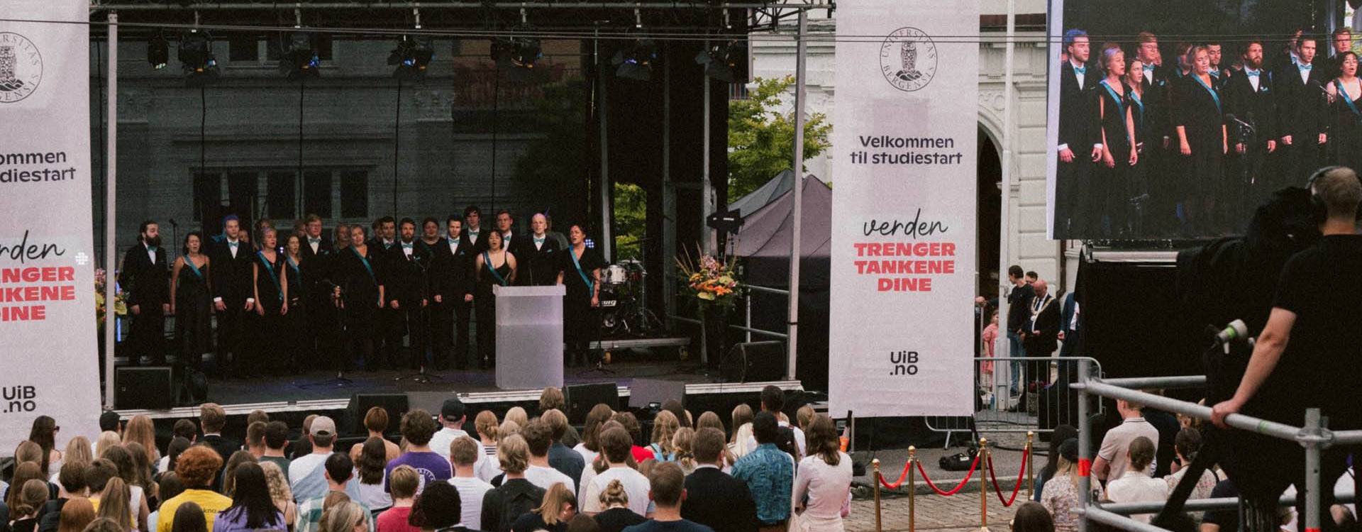 UiBs velkomstseremoni i studiestarten 2022. Scene og rød løper med mye publikum. Kor på scenen.