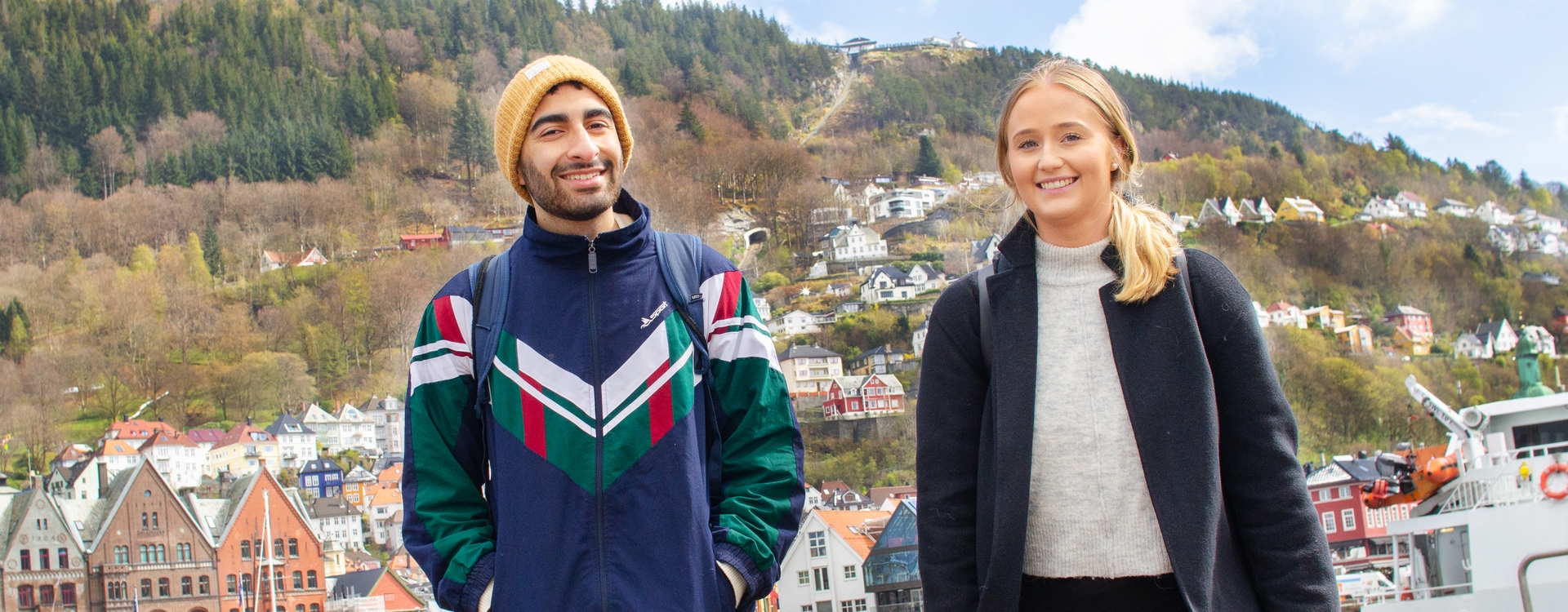 To studenter går på Strandkaiterminalen med Fløyen i bakgrunnen. Foto