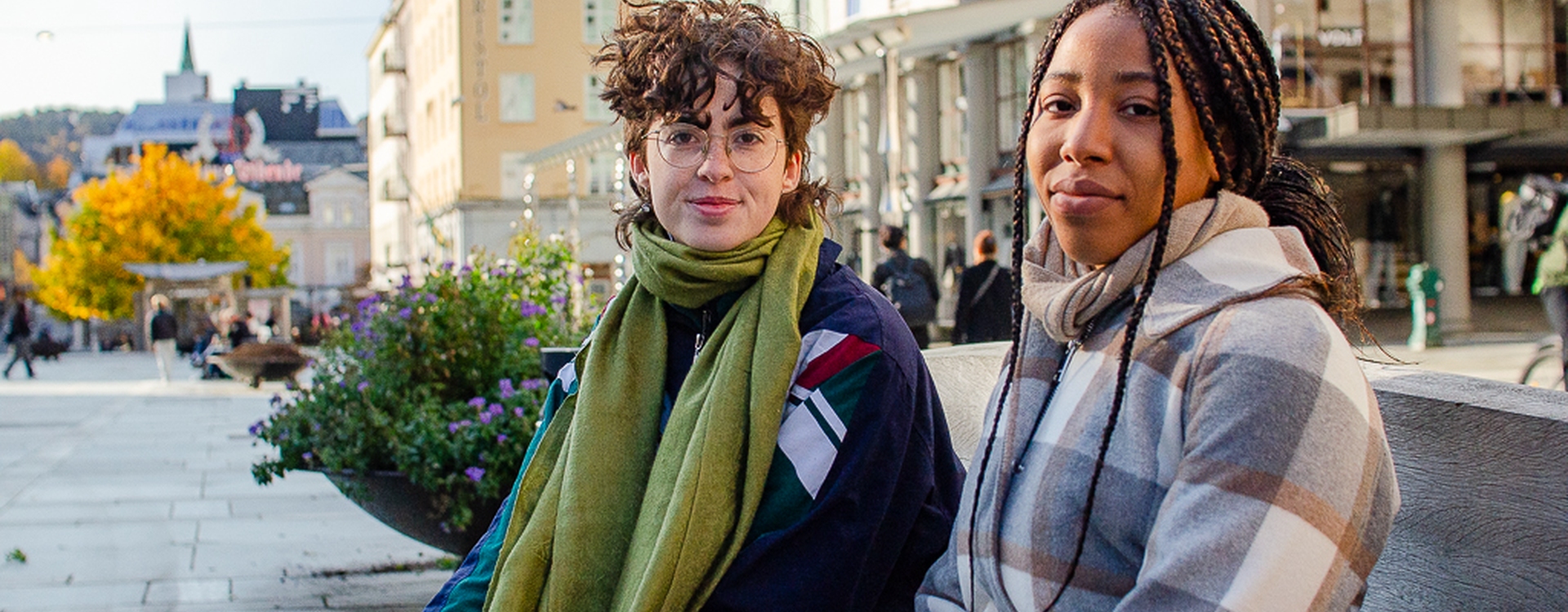 To studenter sitter på en benke i Bergen.