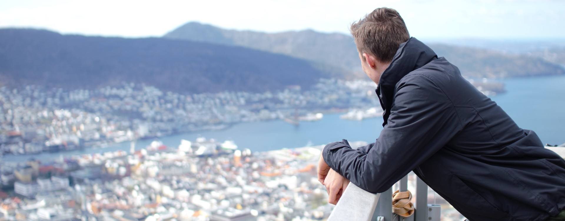 Student looking at Bergen city alone on Mount Fløyen.