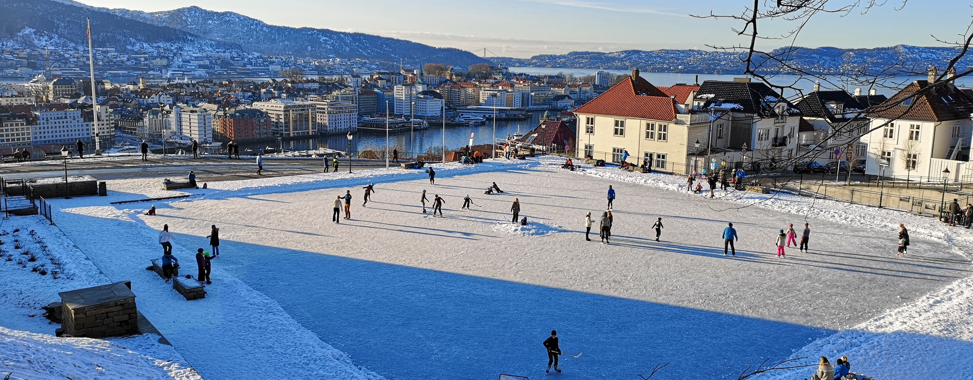 View over Skansedammen in good weather with people ice skaing.
