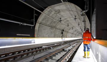 Bilde av en anleggsarbeider i en ny jernbanetunnel