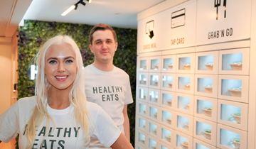 De to gründerne står foran Healthy eats maskiner. 