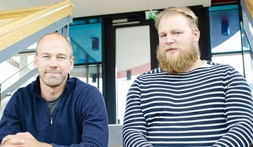 Gründerne sitter ved siden av hverandre og ser i kamera. 