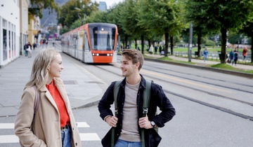 To studenter i Kaigaten i Bergen med Bybanen i bakgrunnen. 