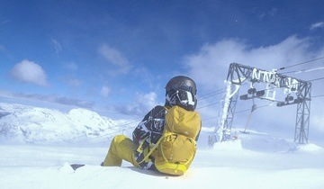 Snowboarder sitter på toppen av Fonna skisenter