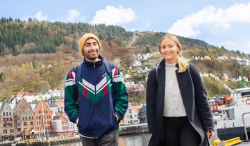 To studenter går på Strandkaiterminalen med Fløyen i bakgrunnen. Foto