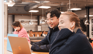 Tre studenter sitter ved laptopene.